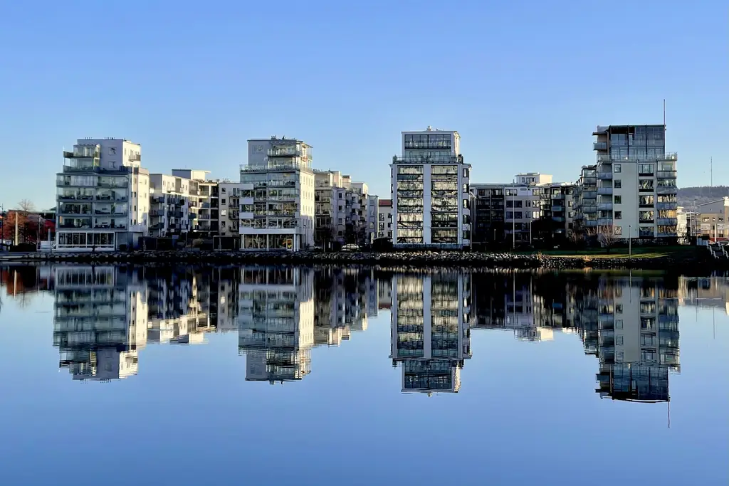 Moderna flerbostadshus som speglar sig i vattnet