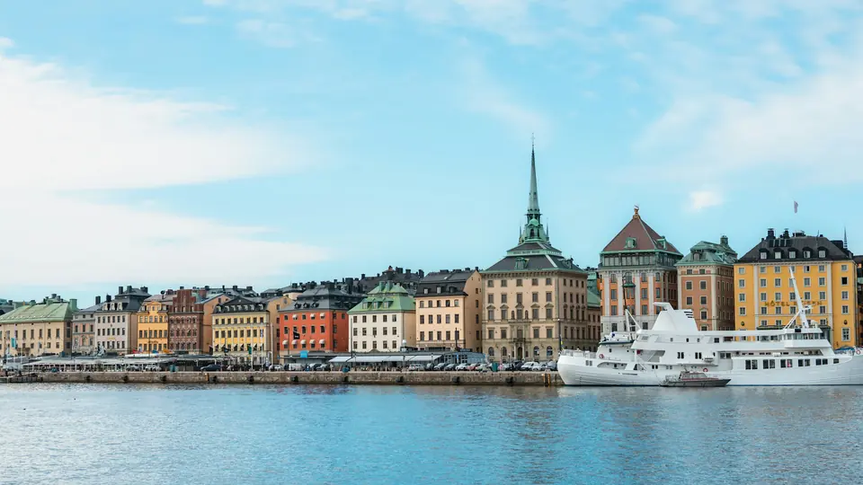 Stockholm sett från vattnet en solig dag, med Gamla stan och båtar vid kajen